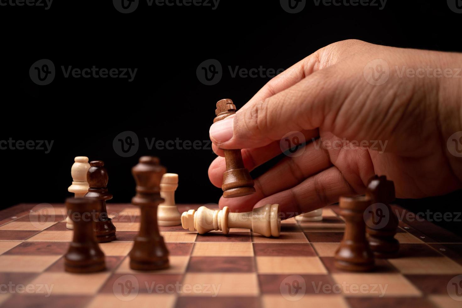Close up of hands confident businessman moving chess figure in competition success play. the chess game is development analysis, strategy, and plan, the management or leadership concept. photo