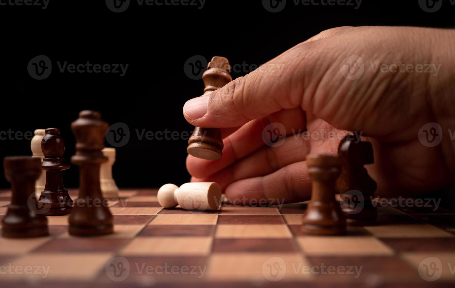 Close up of hands confident businessman moving chess figure in competition success play. the chess game is development analysis, strategy, and plan, the management or leadership concept. photo