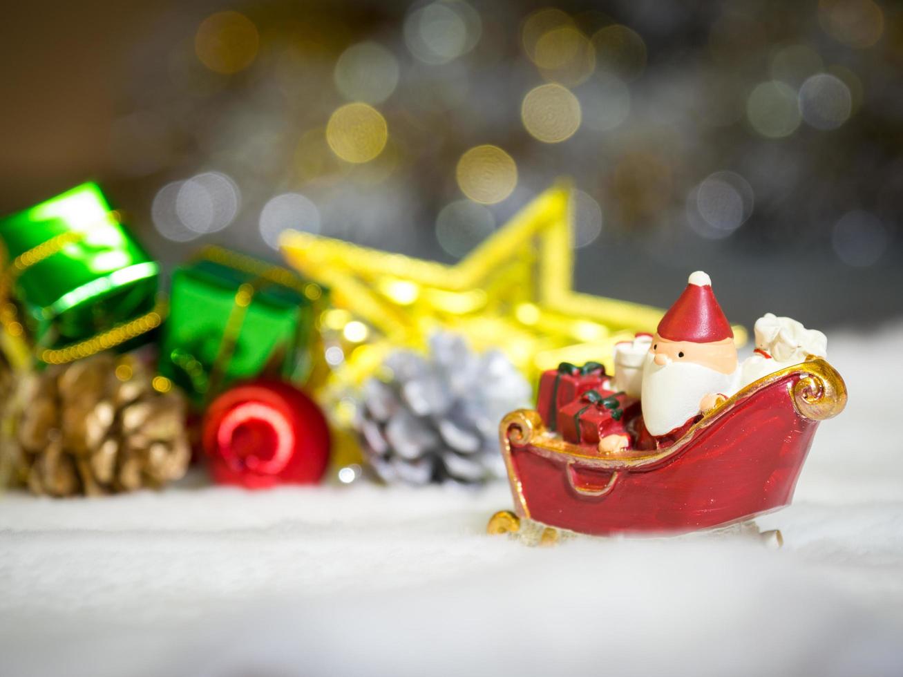 feliz santa claus con caja de regalos en el trineo de nieve el fondo es decoración navideña.santa claus y decoración navideña en la nieve. feliz navidad y feliz año nuevo concepto foto