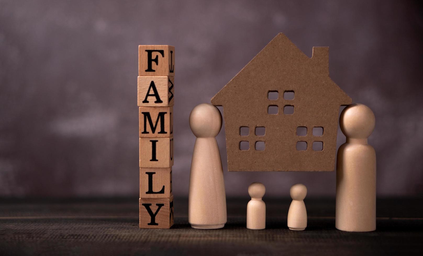 Wooden figures family standing and bear wooden house to Protect and burden the problems to protect the family. The concept of Protection and safety, Home Security, property insurance and house. photo