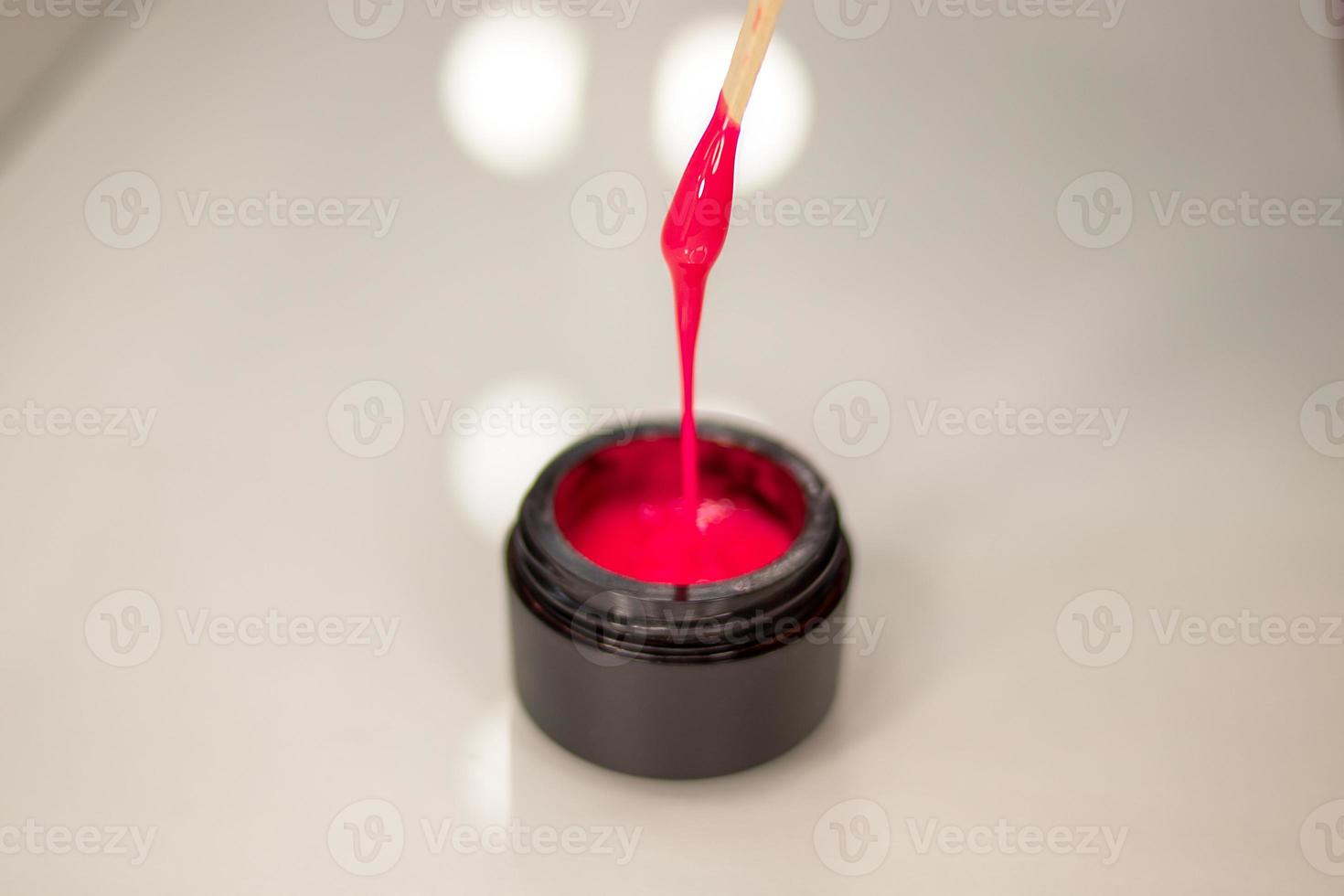 Pink gel nail polish in a jar. Bright gel polish photo