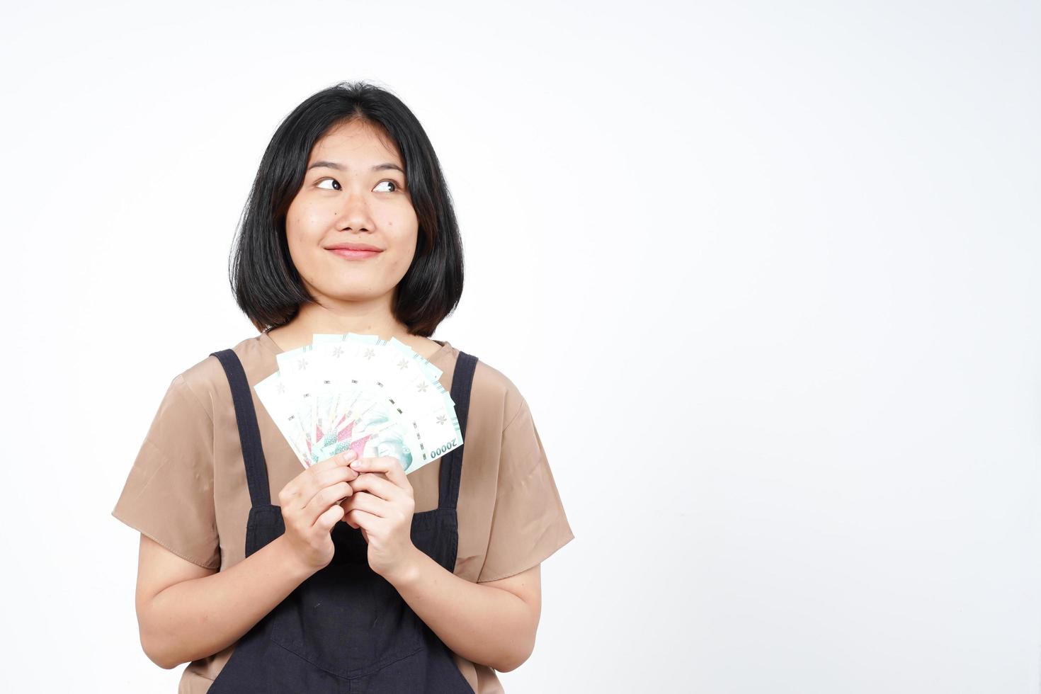 sosteniendo un nuevo billete de indonesia de una hermosa mujer asiática aislada de fondo blanco foto