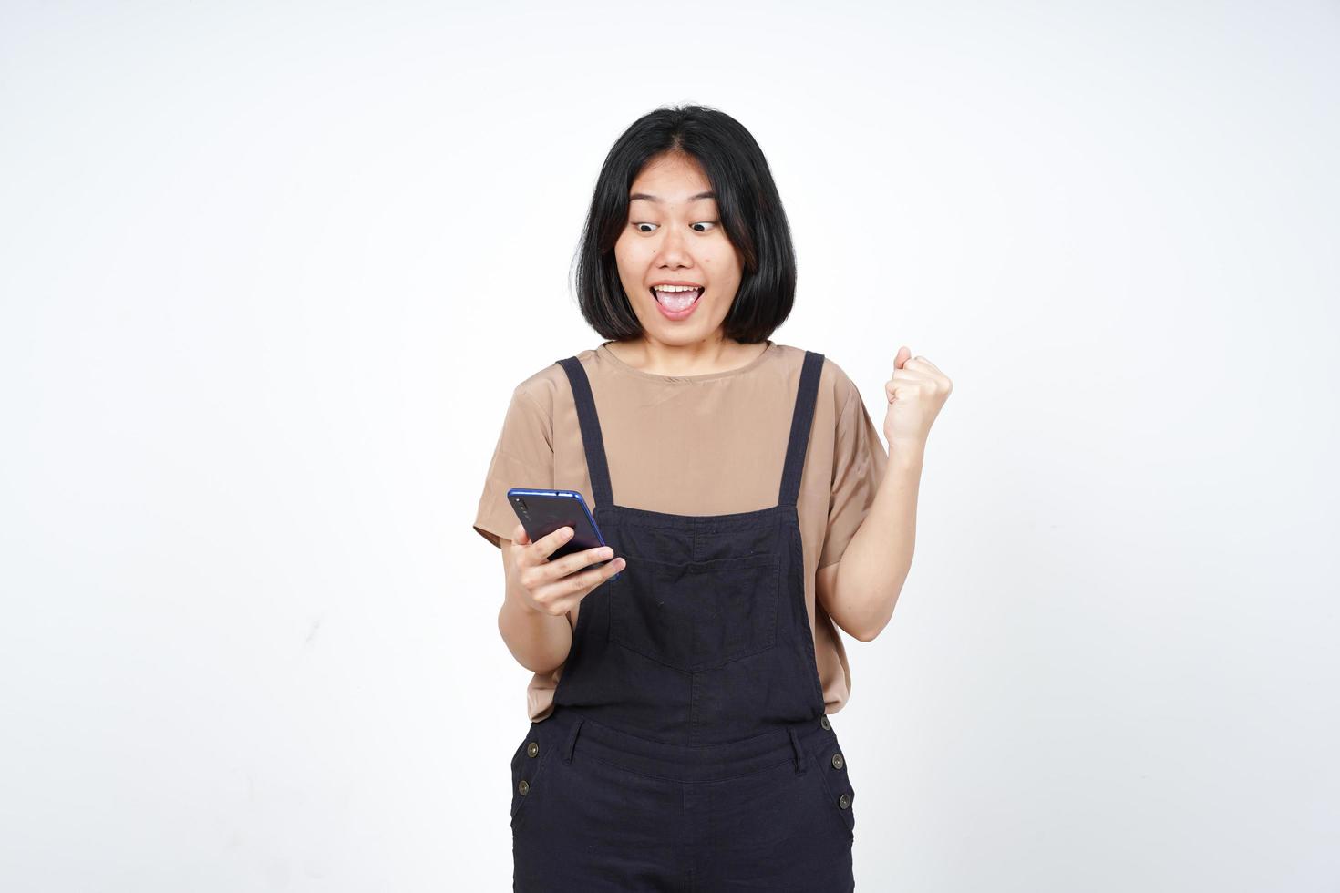 Using Smartphone with yes celebration gesture Of Beautiful Asian Woman Isolated On White Background photo