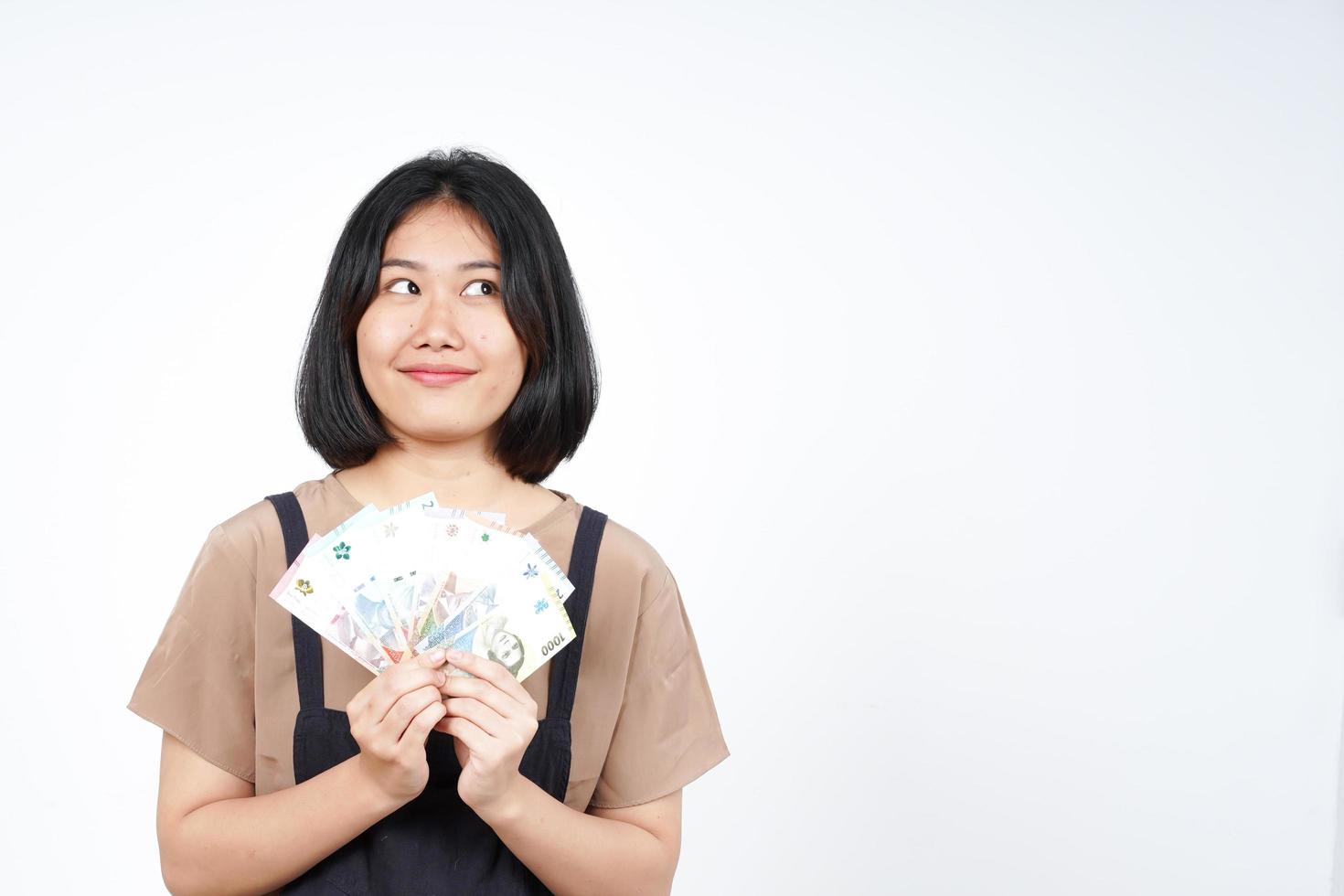 sosteniendo un nuevo billete de indonesia de una hermosa mujer asiática aislada de fondo blanco foto