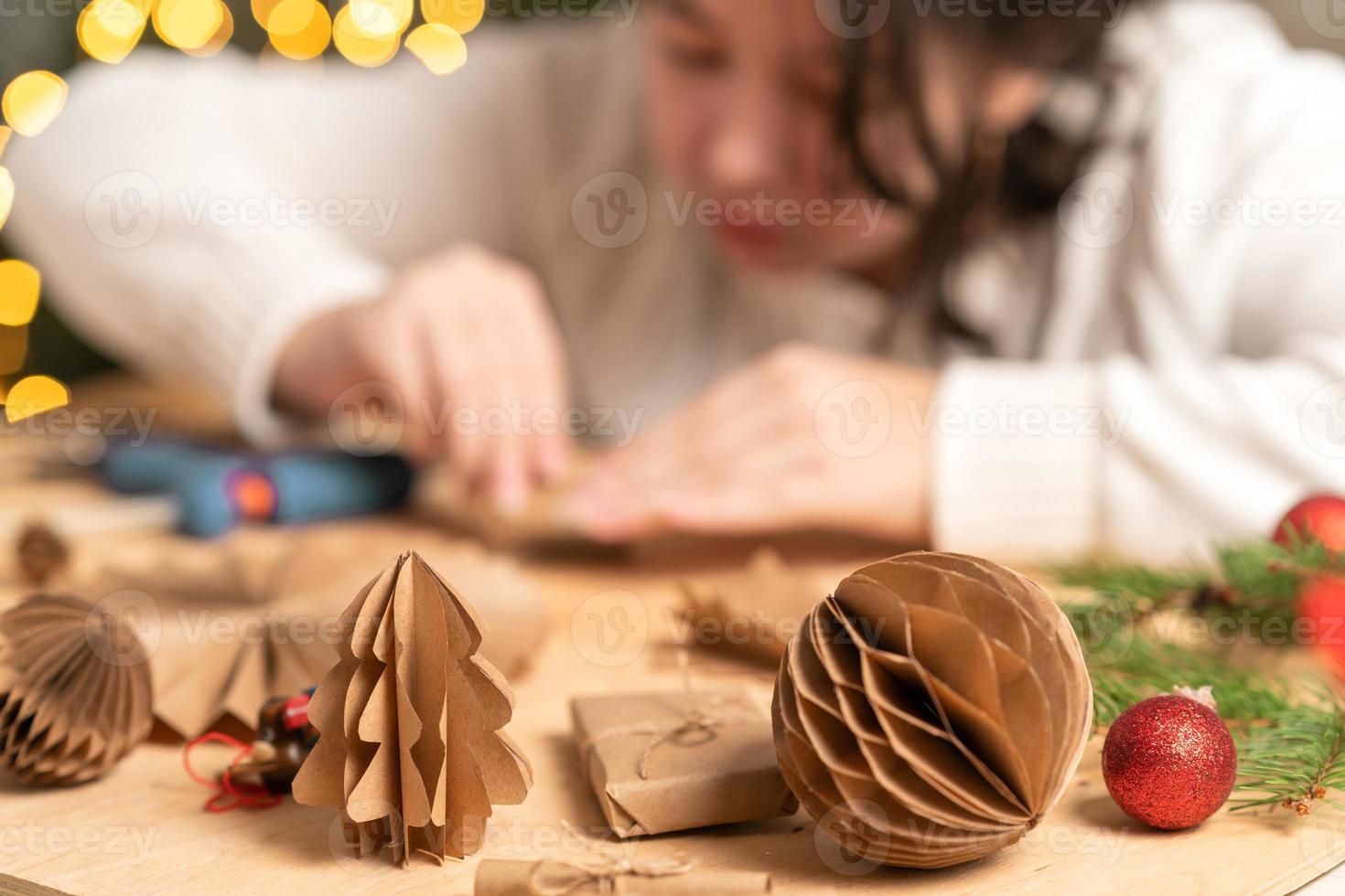 girl makes Christmas tree decorations out of paper with her own hands. step-by-step instruction photo