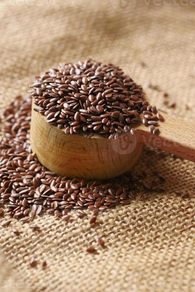 close up of flax seeds on wooden spoon on table photo