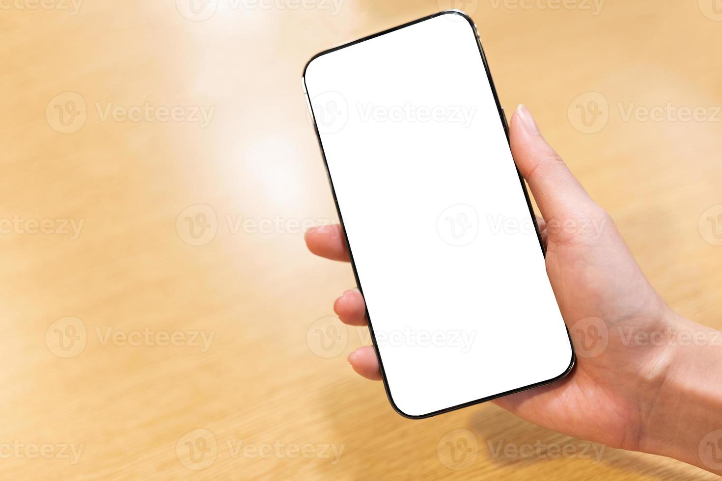 nuevo modelo de smartphone con pantalla completa en la mano derecha de la mujer. cierre la mano que sostiene el teléfono inteligente negro con pantalla blanca. foto
