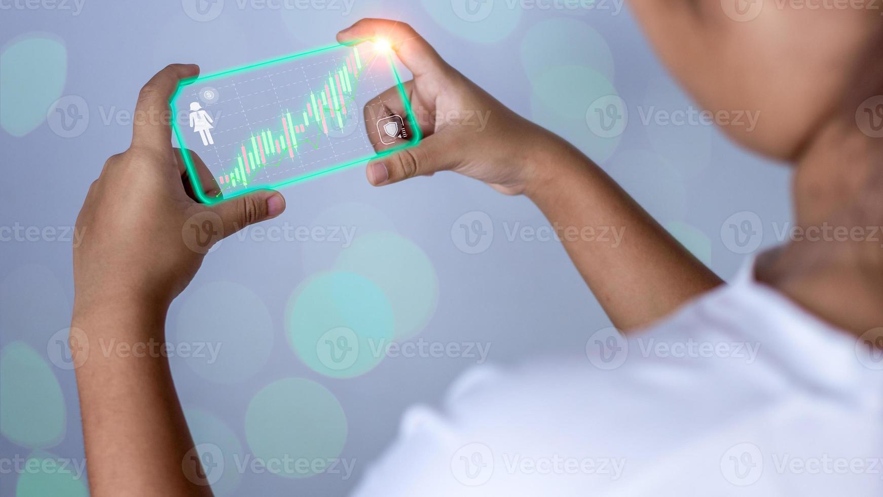 Hologram image of a candlestick chart from a phone on a person's hand. Offer trading concept, investment ideas photo