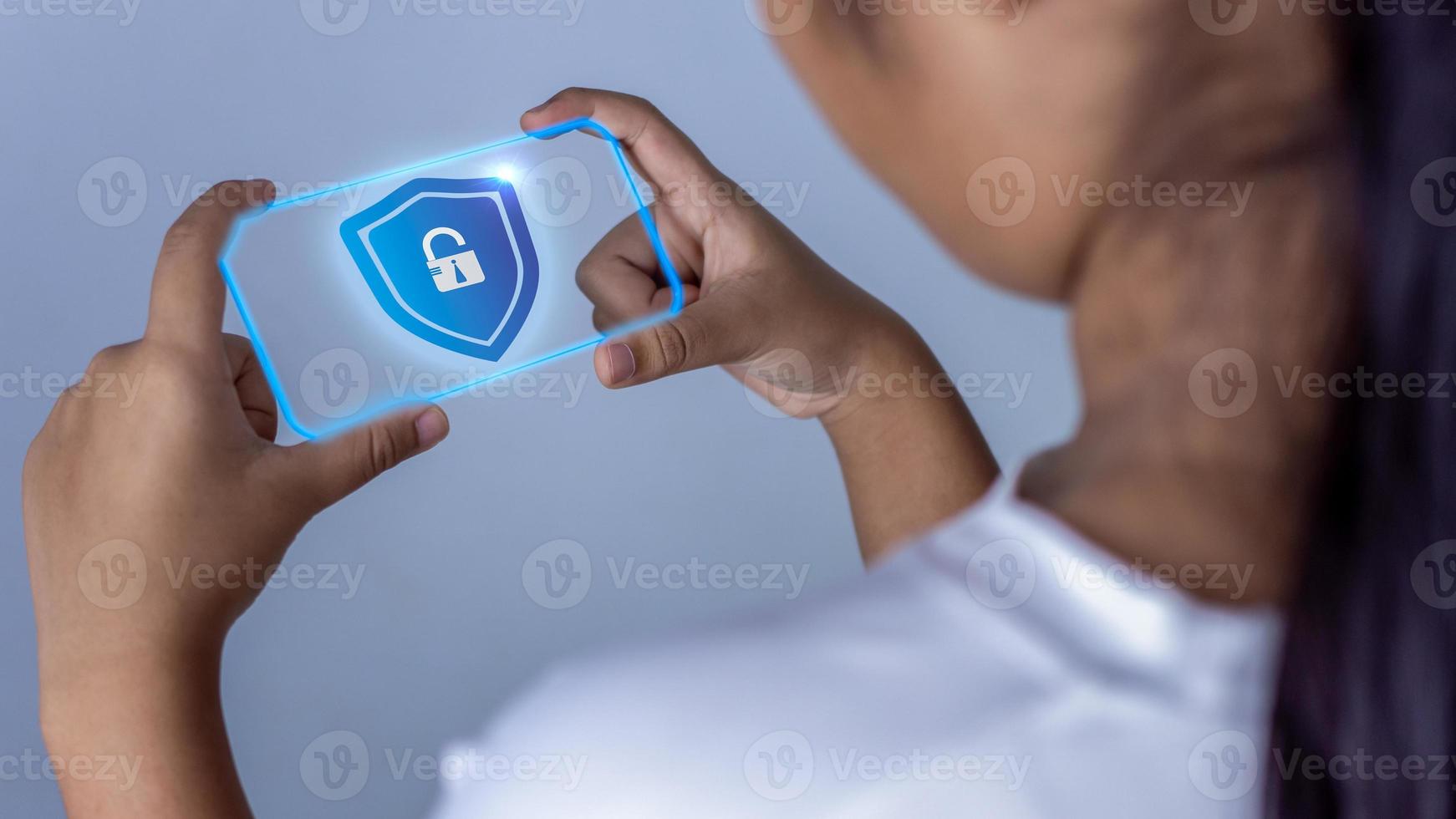 Woman holding phone tablet screen with protection icon. Represents protection against external hacks. Security concepts against code, virus, firmware and malware. photo