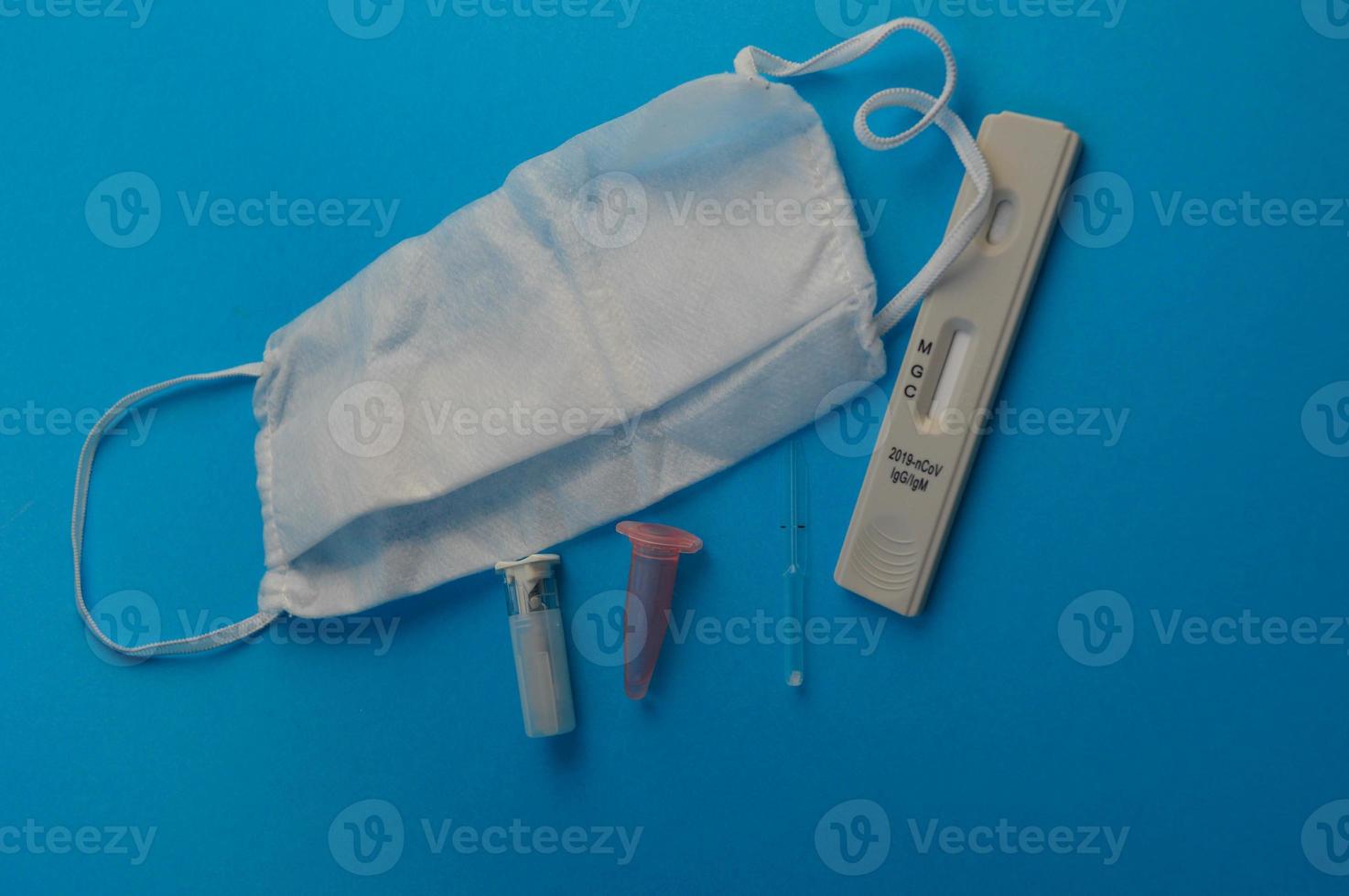 antibody test. next to the test, a disposable mask, a lancet and a pipette for taking an analysis with a container for blood. blood analysis. self-diagnosis for coronavirus photo