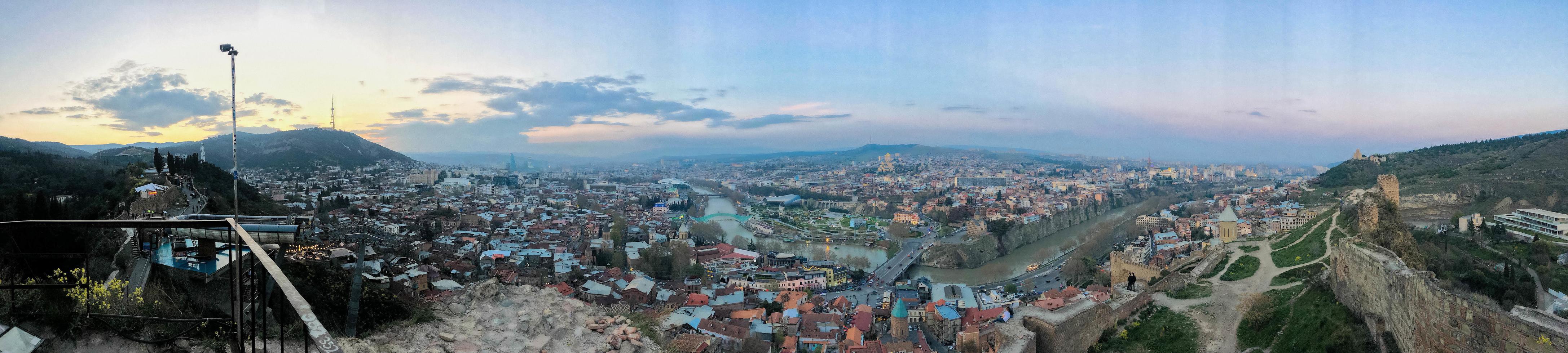 Large panorama with a view from the height of a beautiful tourist city with buildings and houses, trees and plants, nature against the blue sky. European old architecture photo