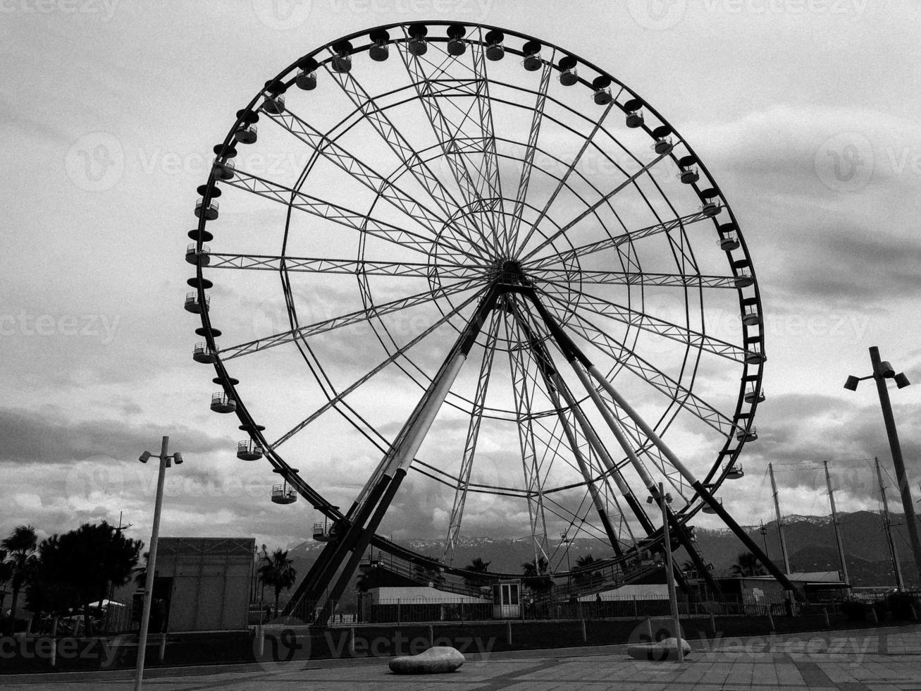 A large round beautiful Ferris wheel, a panoramic platform in a park on a tropical sea warm summer resort with palm trees against a blue sky photo