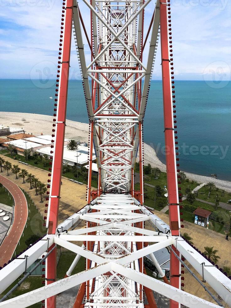 Metallic white iron construction of the pipes, the mechanism of the Ferris wheel is not the backdrop of a seaside resort with palm trees. Inside view photo