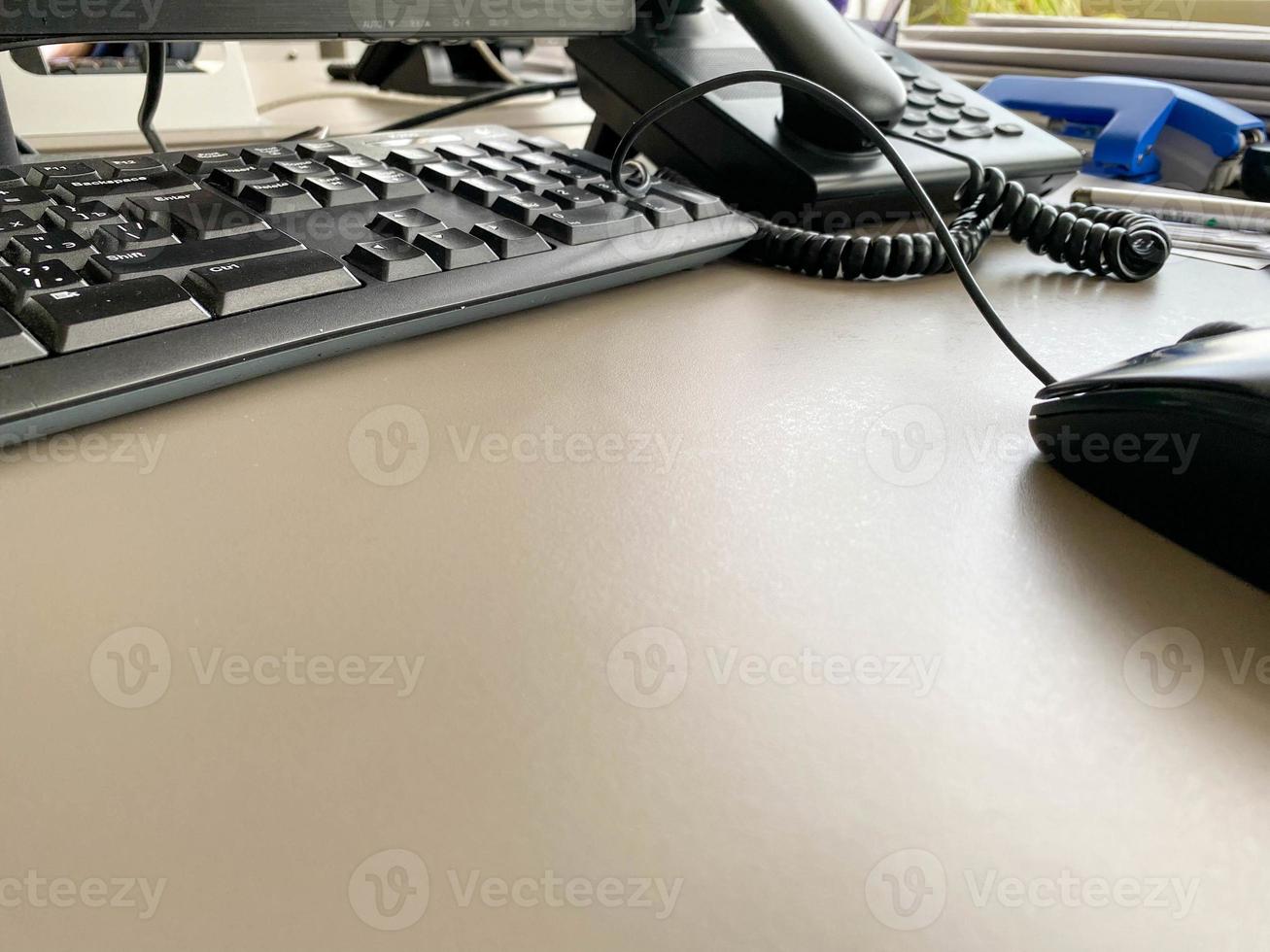 teclado de ratón de computadora moderno negro y teléfono en una mesa de trabajo en una empresa de negocios foto