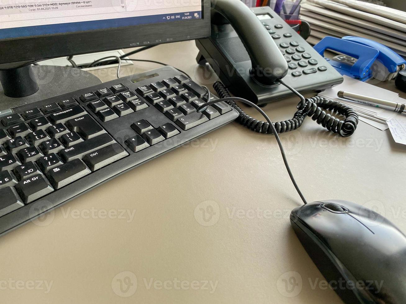 teclado de ratón de computadora moderno negro y teléfono en una mesa de trabajo en una empresa de negocios foto