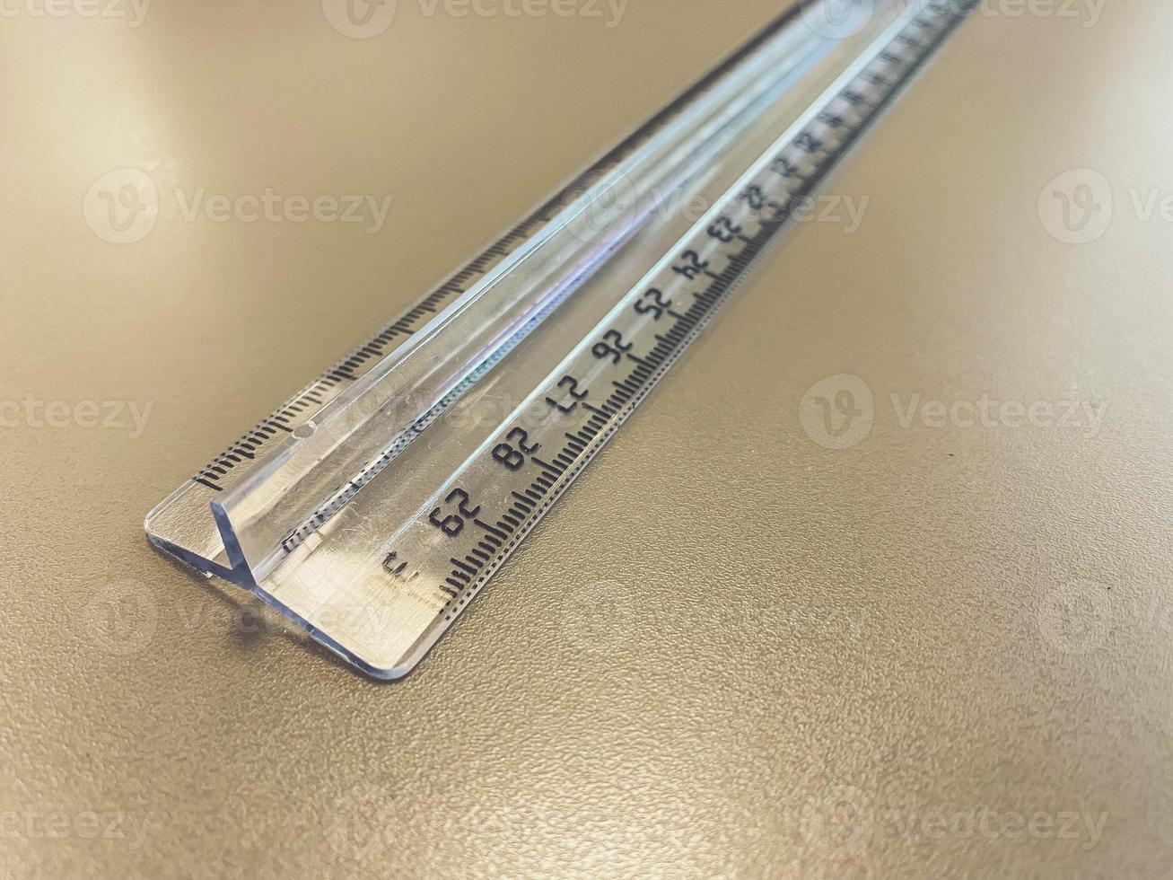 a transparent, long, centimeter ruler lies on the table. supplies for mathematics and geometry. stationery and office supplies for work photo