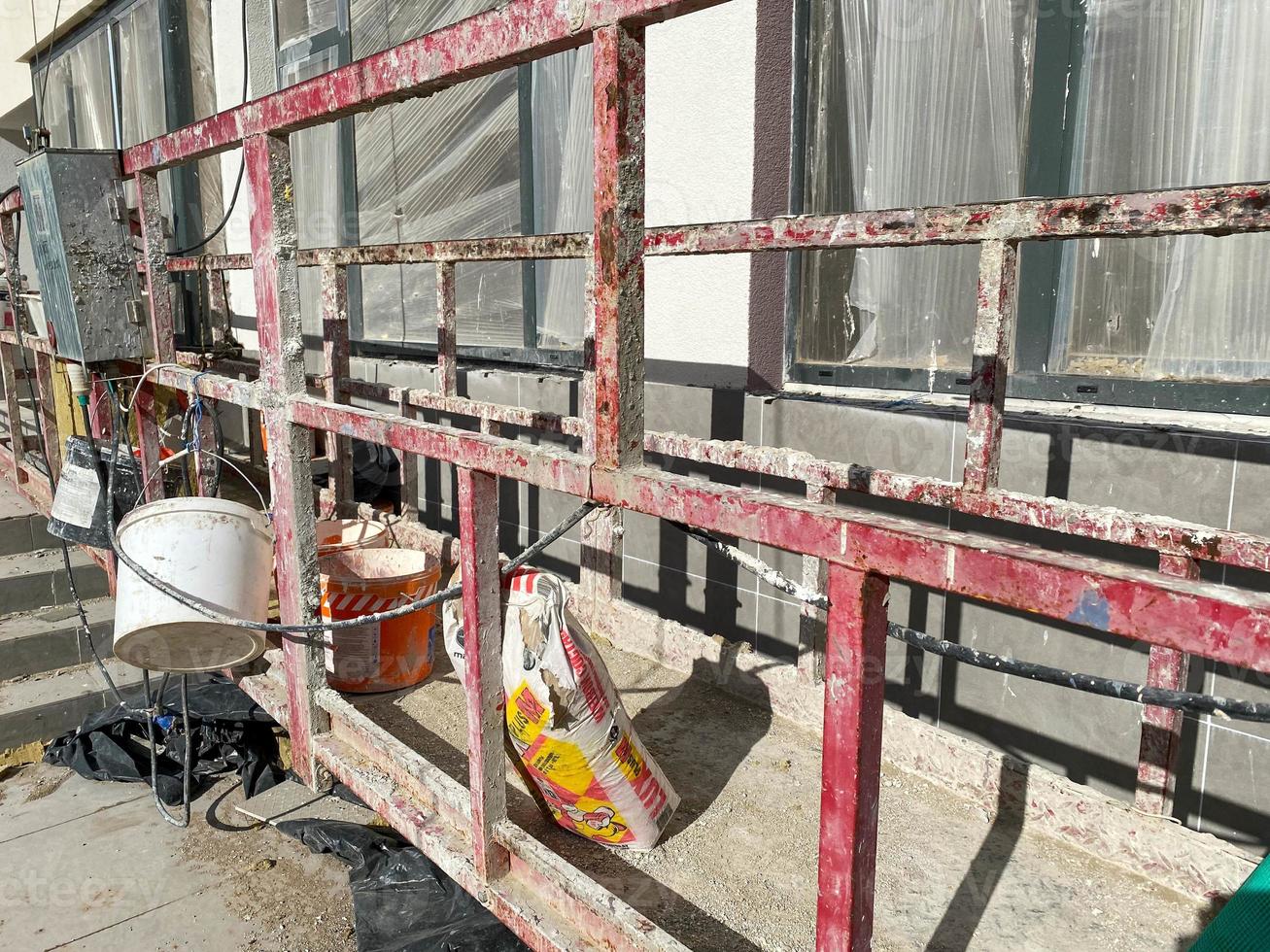 View of the facade of a new multi-storey building under construction. Suspended cradle on the facade of the skyscraper. Mobile scaffolding platform for construction work at height photo