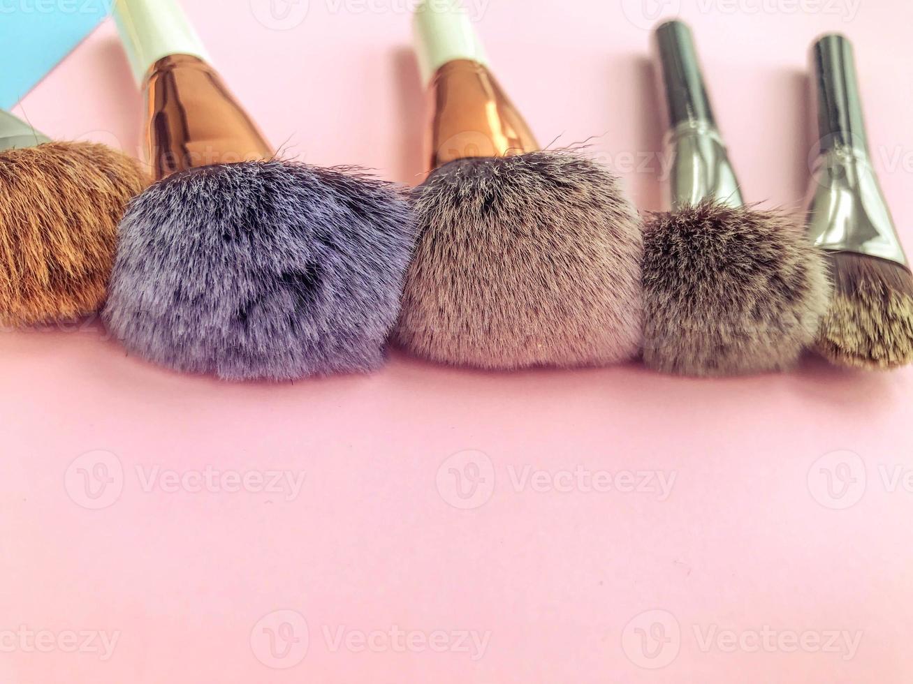 Set of different makeup brushes, makeup tools on pastel blue and beige pink background photo