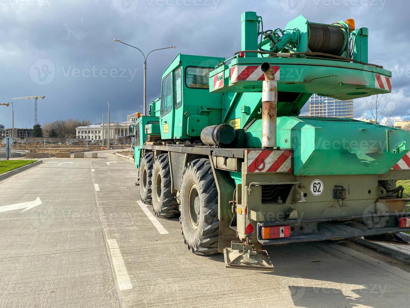 Large powerful new industrial green construction crane used in the construction of new areas of the city. Special construction equipment photo
