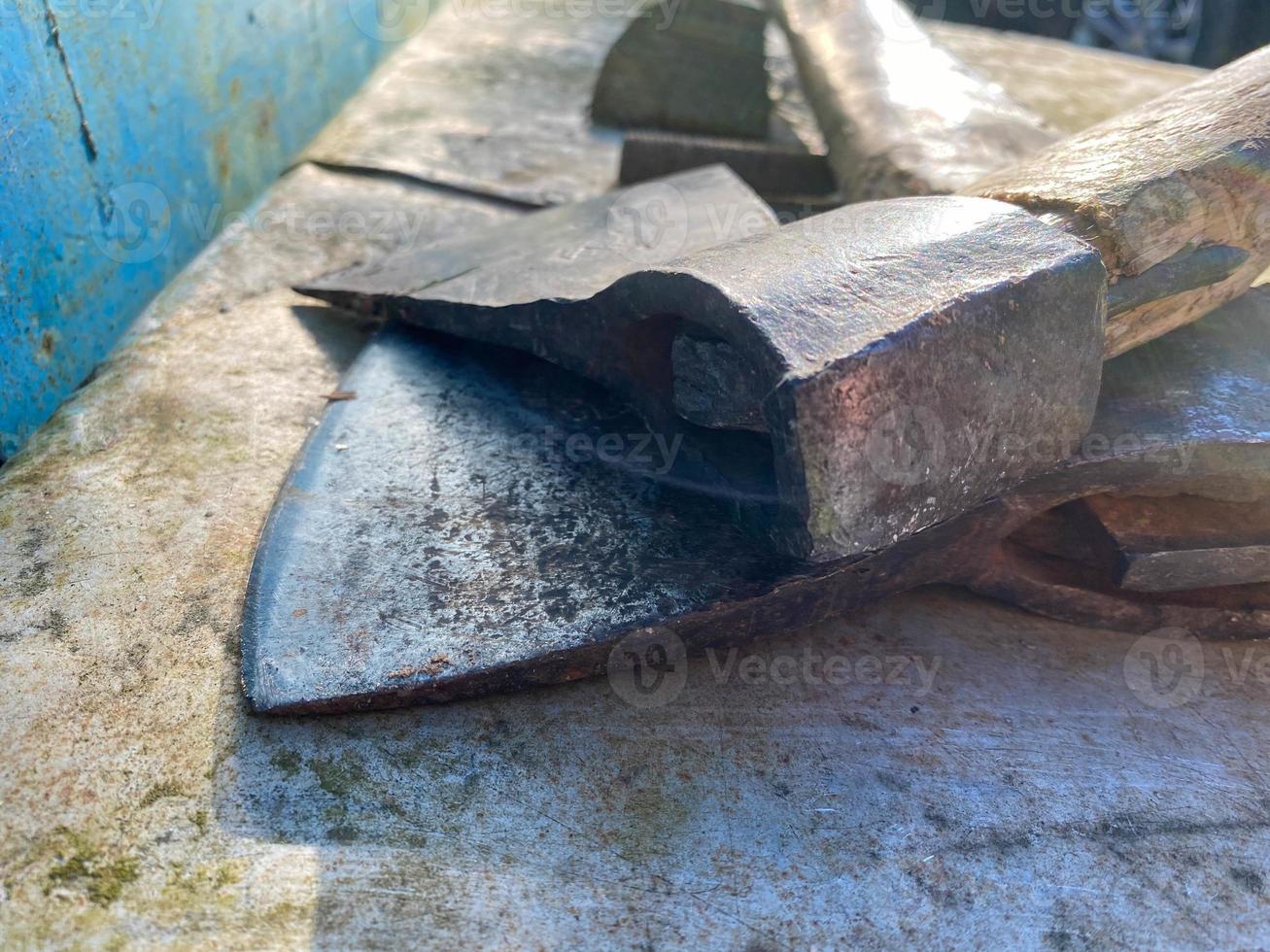 un viejo hacha de metal de hierro con un trasero y un hermoso mango oxidado y de textura para cortar leña, madera y árboles se encuentra sobre un fondo de hierro foto