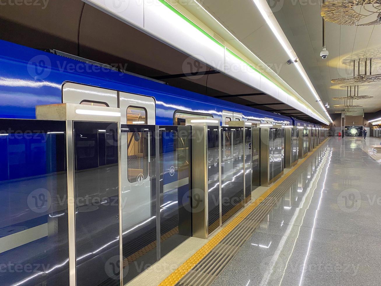 nuevo tren subterráneo azul moderno de alta velocidad rápido y seguro en la gran ciudad en la plataforma de espera en la estación de metro en la estación de tren foto