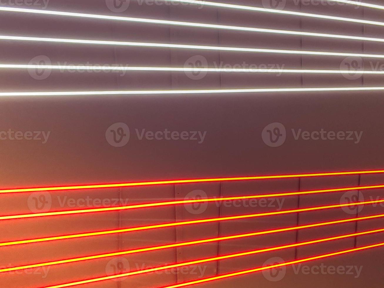 Texture of red and white glowing bright neon LED multicolored laser abstract stripes and lines from parallel lamps. The background photo