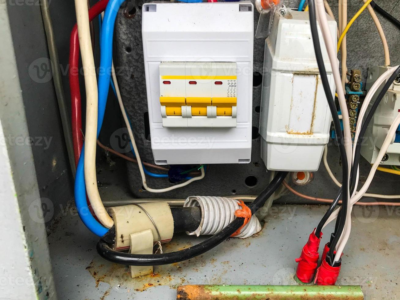 homemade electrical panel. gray meter with energy consumption indicator. thick wires for transmitting current. braiding thick cables for power transmission photo