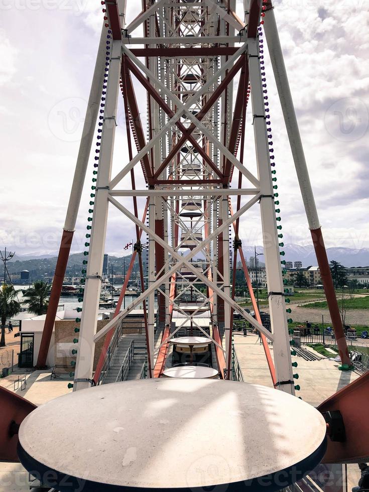 Metallic white iron construction of pipes, the mechanism of the Ferris wheel is not against the backdrop of the mountains. Inside view photo