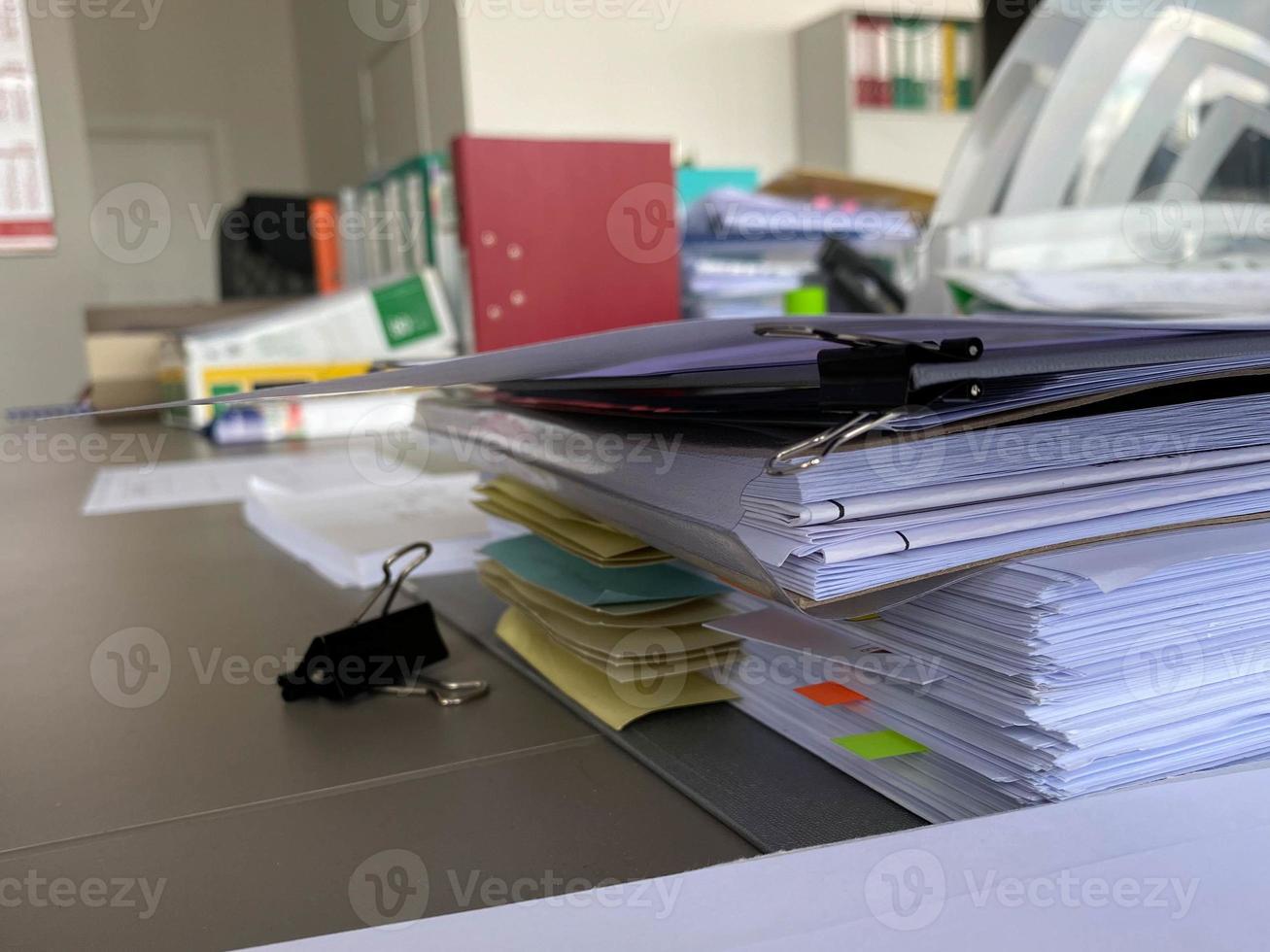 Large thick folders with important papers and documents on a working office desk with stationery and accessories photo