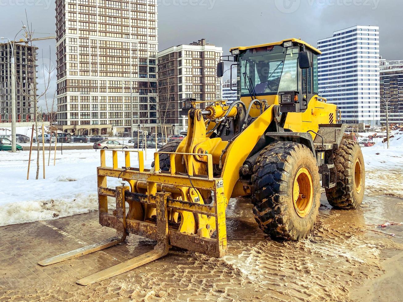 construction equipment on site. construction of houses. bright, yellow forklift transports heavy loads with a metal attachment. lifting, large, construction machinery photo