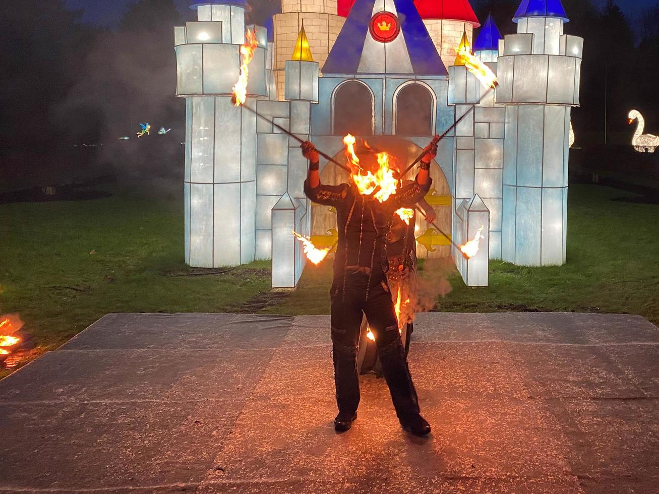 Fire show. Dancers with lit burning sticks for creative performance and dance with fire in the dark at night photo