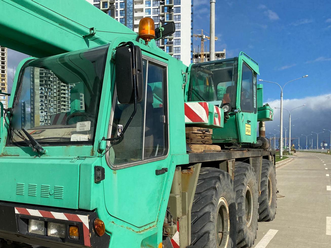 Large powerful new industrial green construction crane used in the construction of new areas of the city. Special construction equipment photo