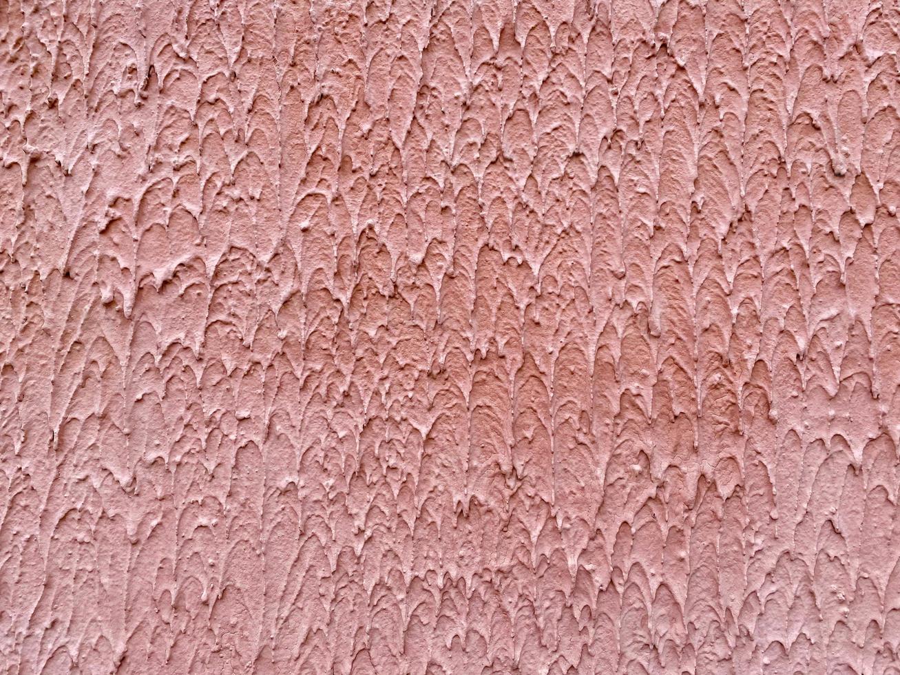 Red texture of decorative plaster bark beetle with thorns and a rough surface. The background photo