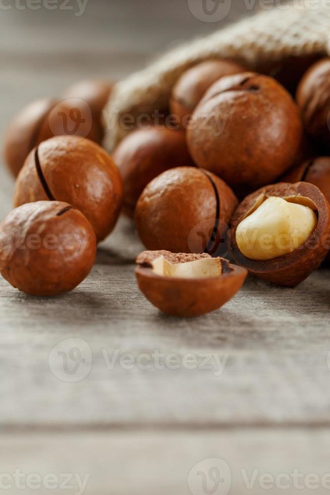 nuez de macadamia en una mesa de madera en una bolsa, primer plano, vista superior foto