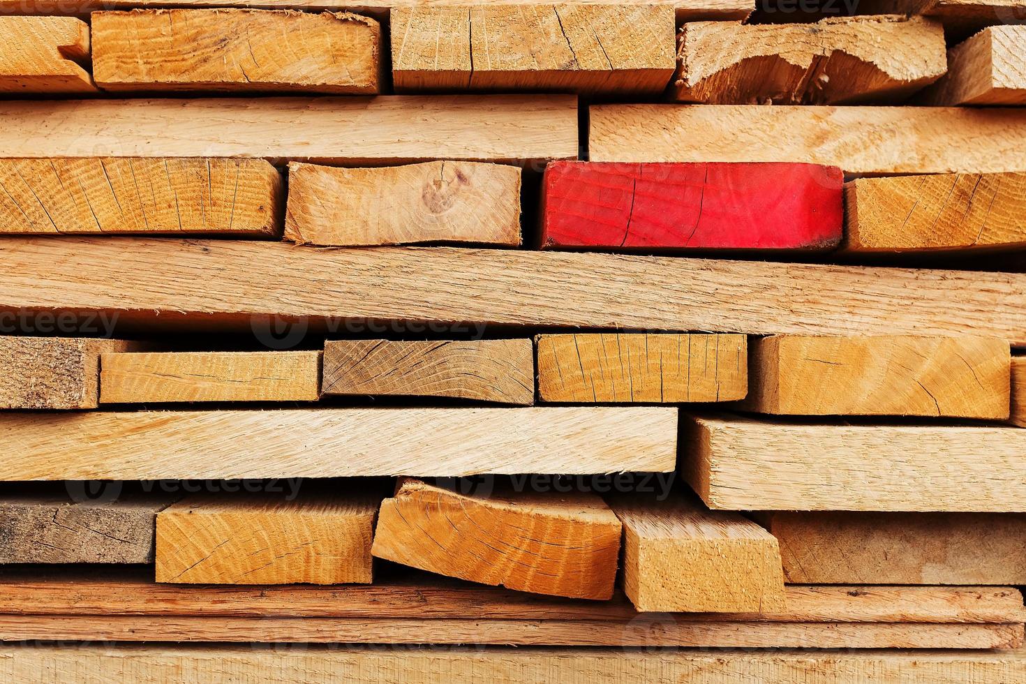 Sawn and folded boards with an emphasis on one red board, construction boards, full-screen lumber as a background. photo