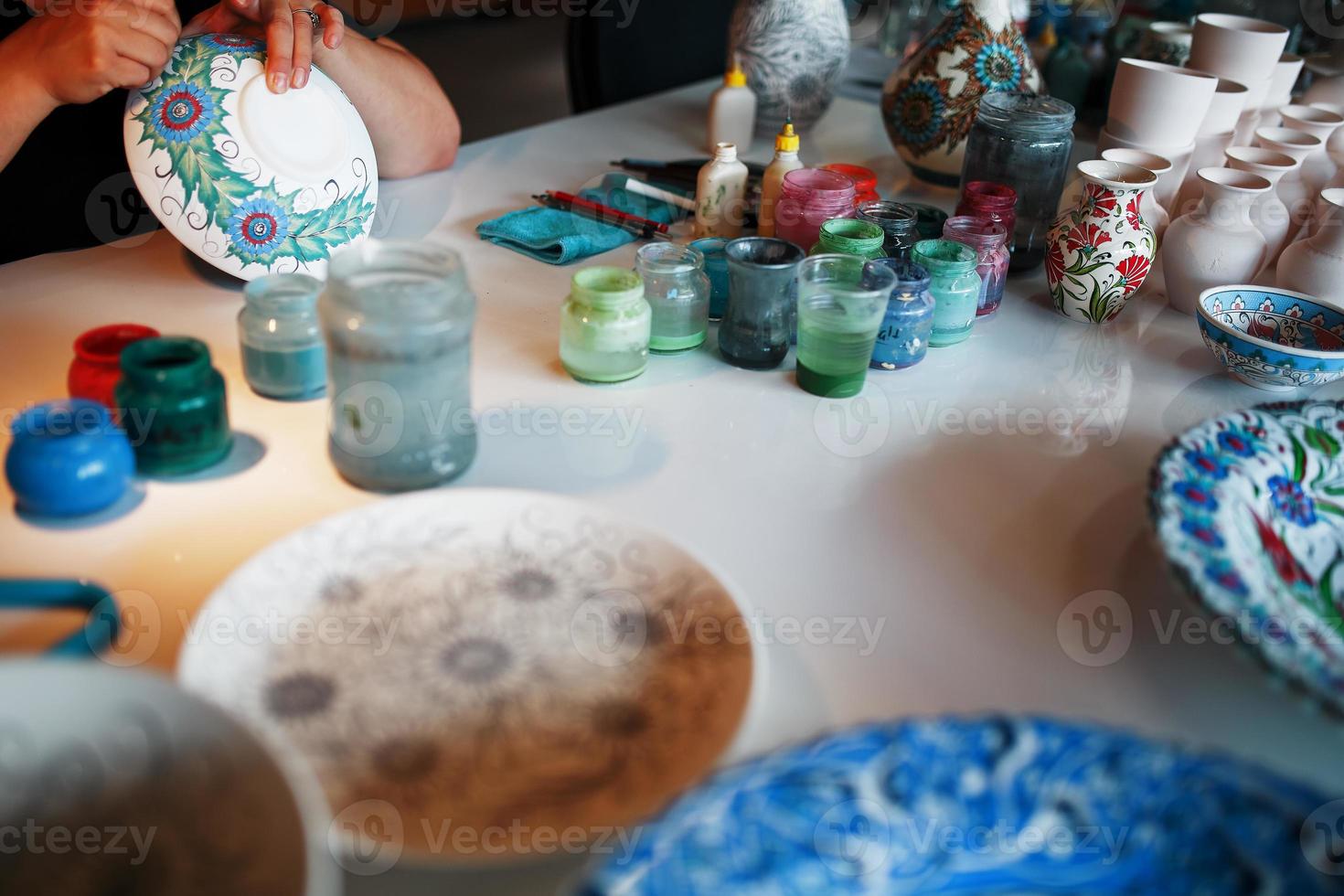 pintar platos de porcelana con las manos de un artesano profesional. foto