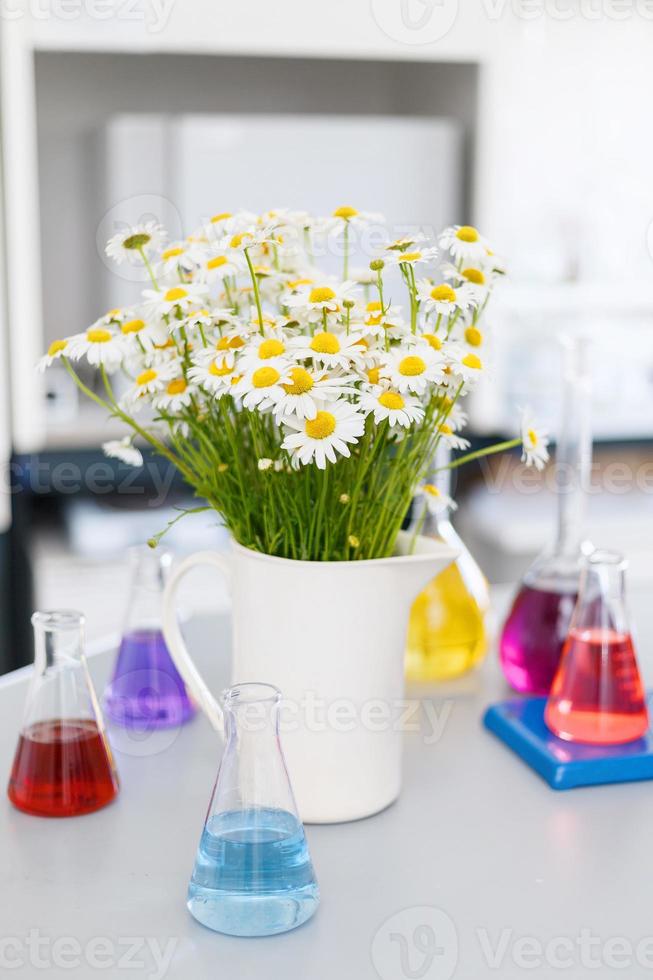 Chemical laboratory flask with blue purple-pink liquid stand on the table photo