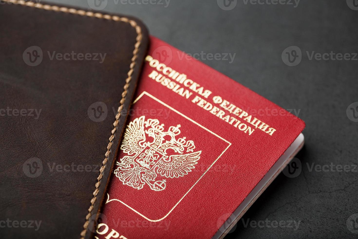 Brown leather cover with a red passport on a dark background photo