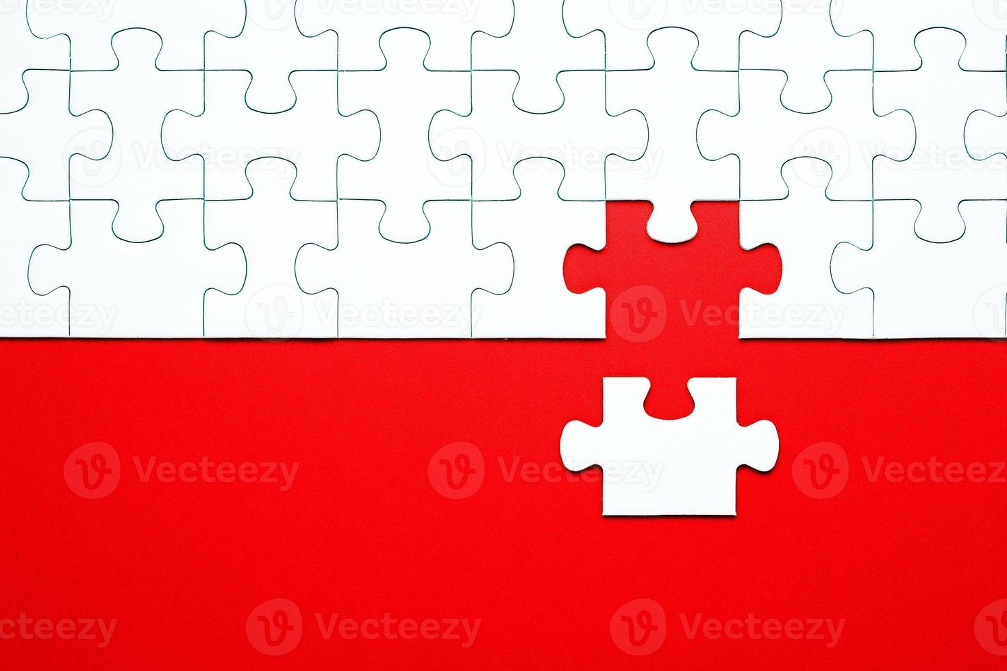 White puzzle pieces on a red background separated photo