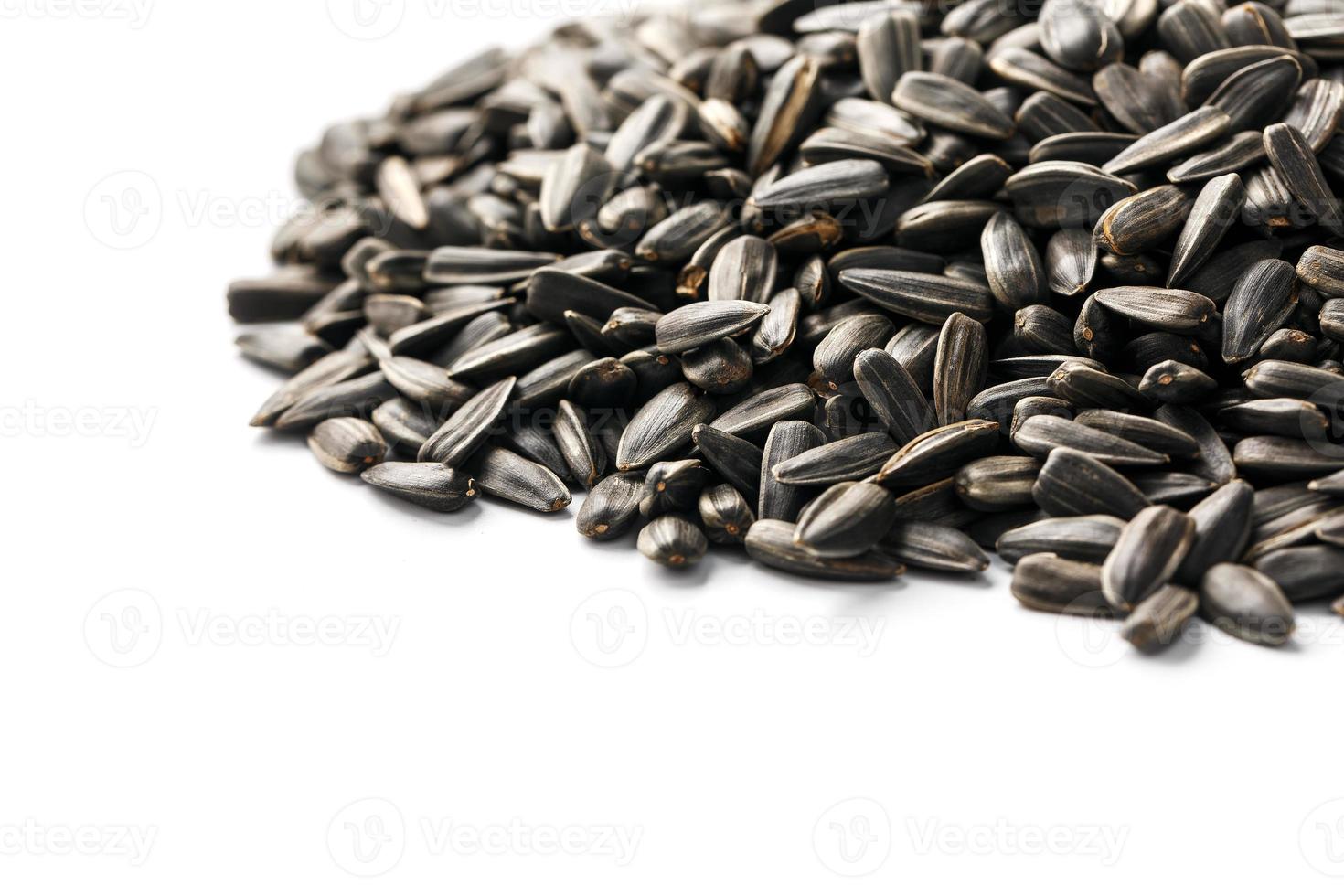 Seeds in a black shell are a bunch on a white background. In full screen photo
