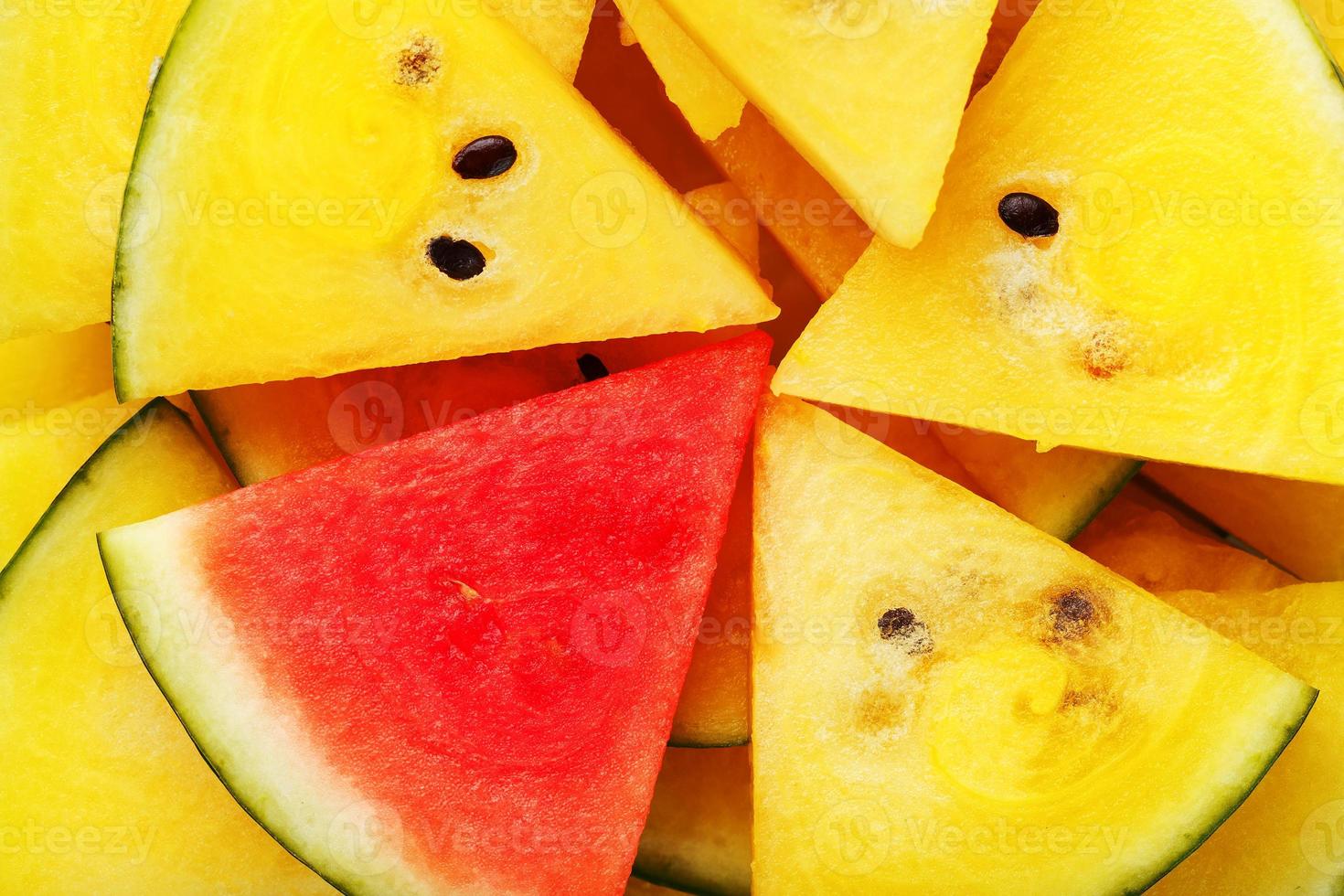 Pieces of red and yellow watermelon in a plate. A slice of red watermelon is one among the yellow pieces. Highlight photo