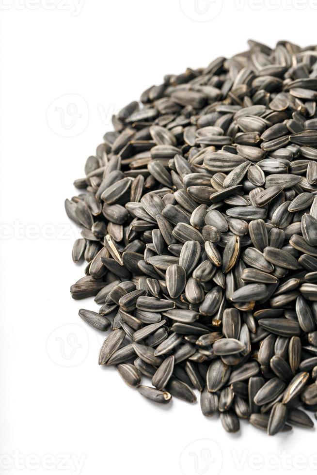 Seeds in a black shell are a bunch on a white background. In full screen photo