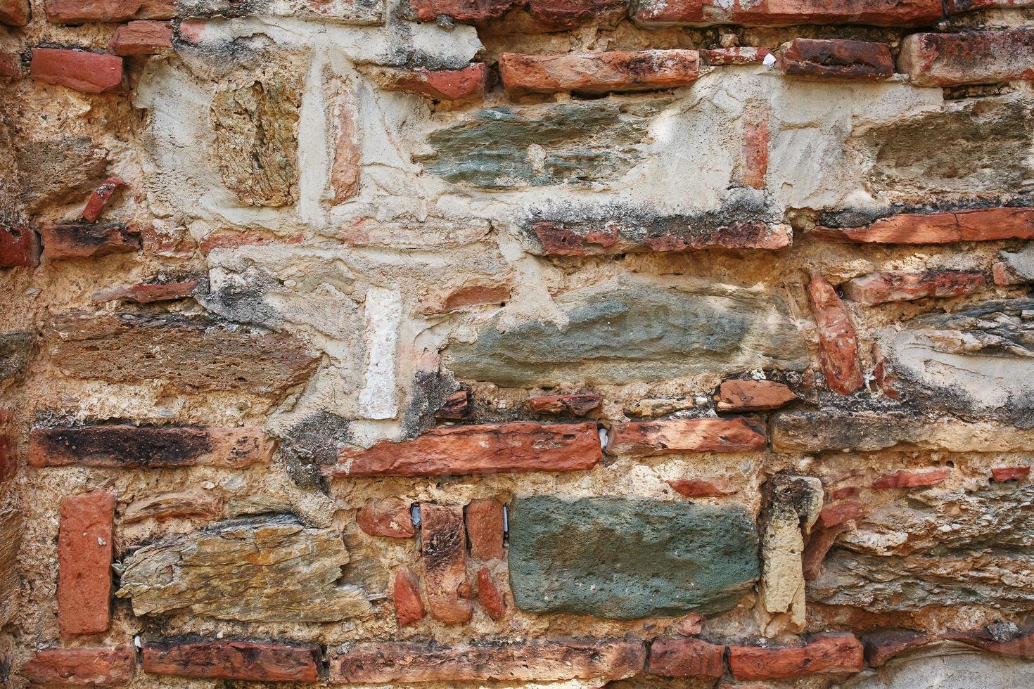 antiguo muro de piedra gris enmarcado por ladrillo rojo. albañilería turca. foto