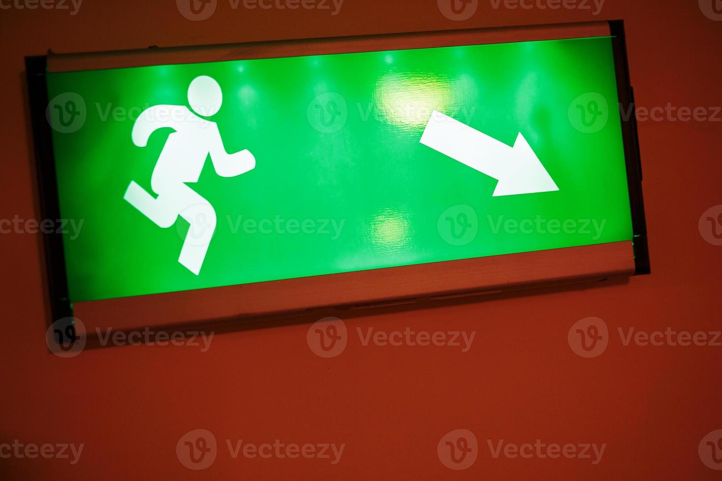 Green escape route sign on a flight of stairs. photo