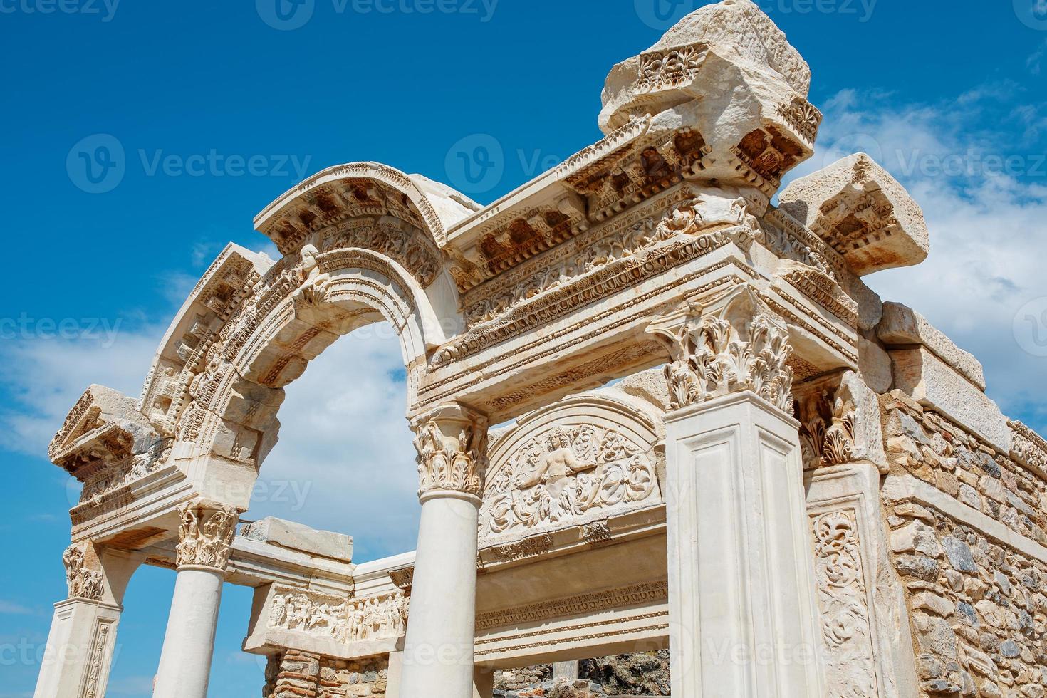 Ruins of the ancient urban architecture of the city of Ephesus, against the blue sky Temple of Hadrian. photo