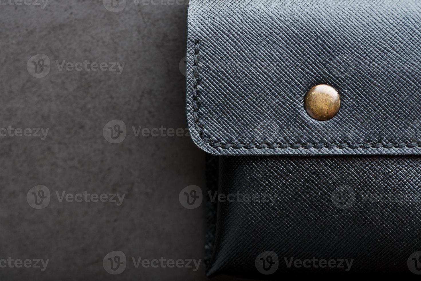 Black wallet made of genuine leather on a dark background. Handmade leather items photo