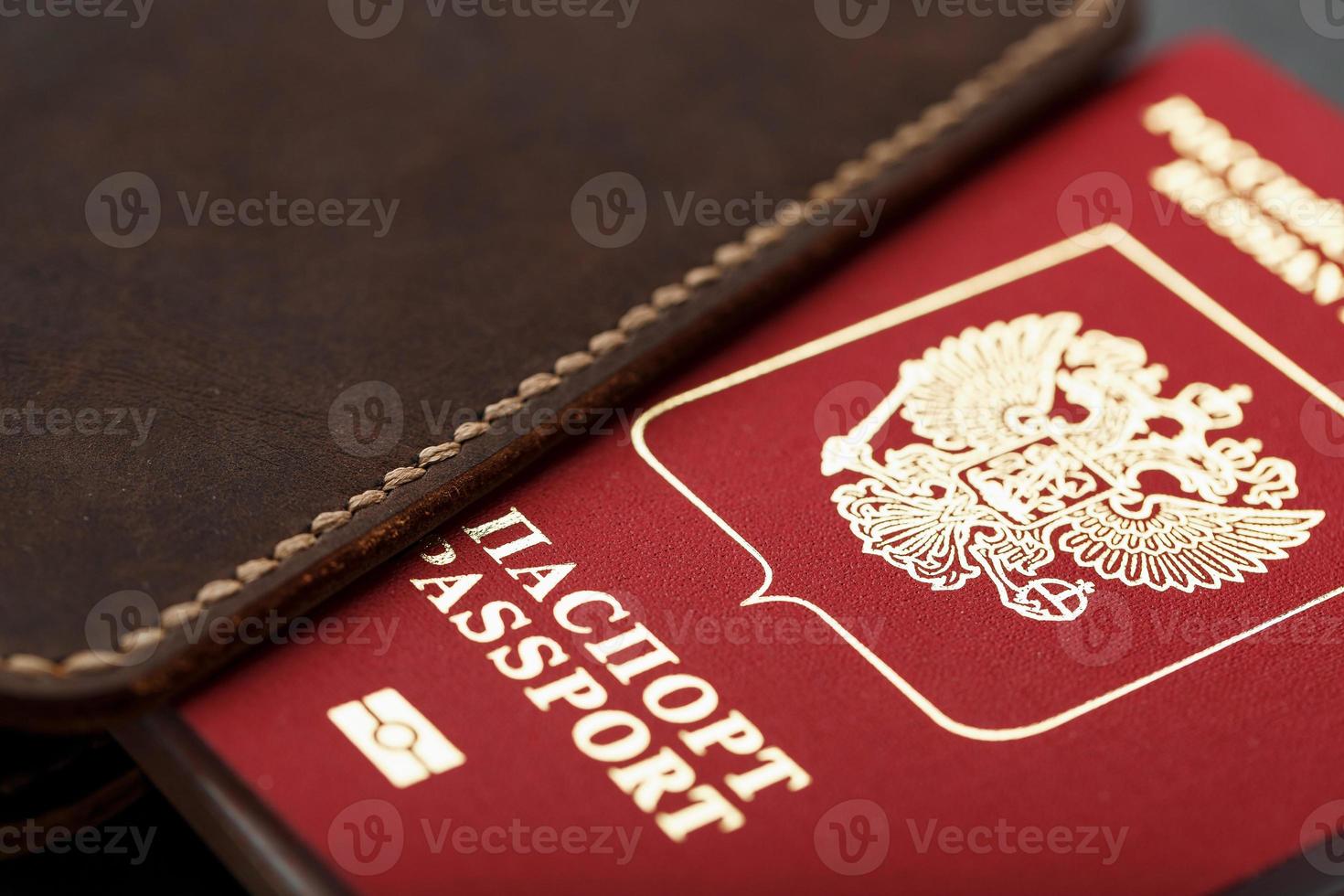 Brown leather cover with a red passport on a dark background photo