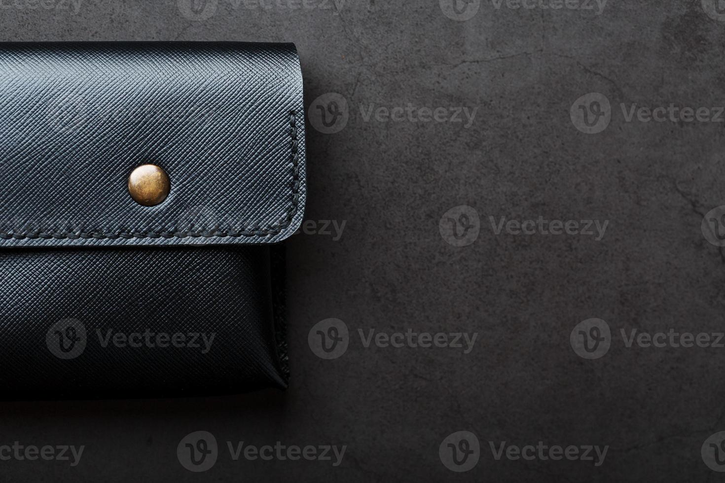 Black wallet made of genuine leather on a dark background. Handmade leather items photo