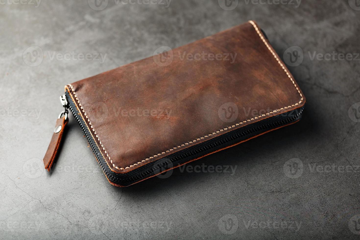 Organizer wallet made of brown Genuine leather, handmade on a dark background photo