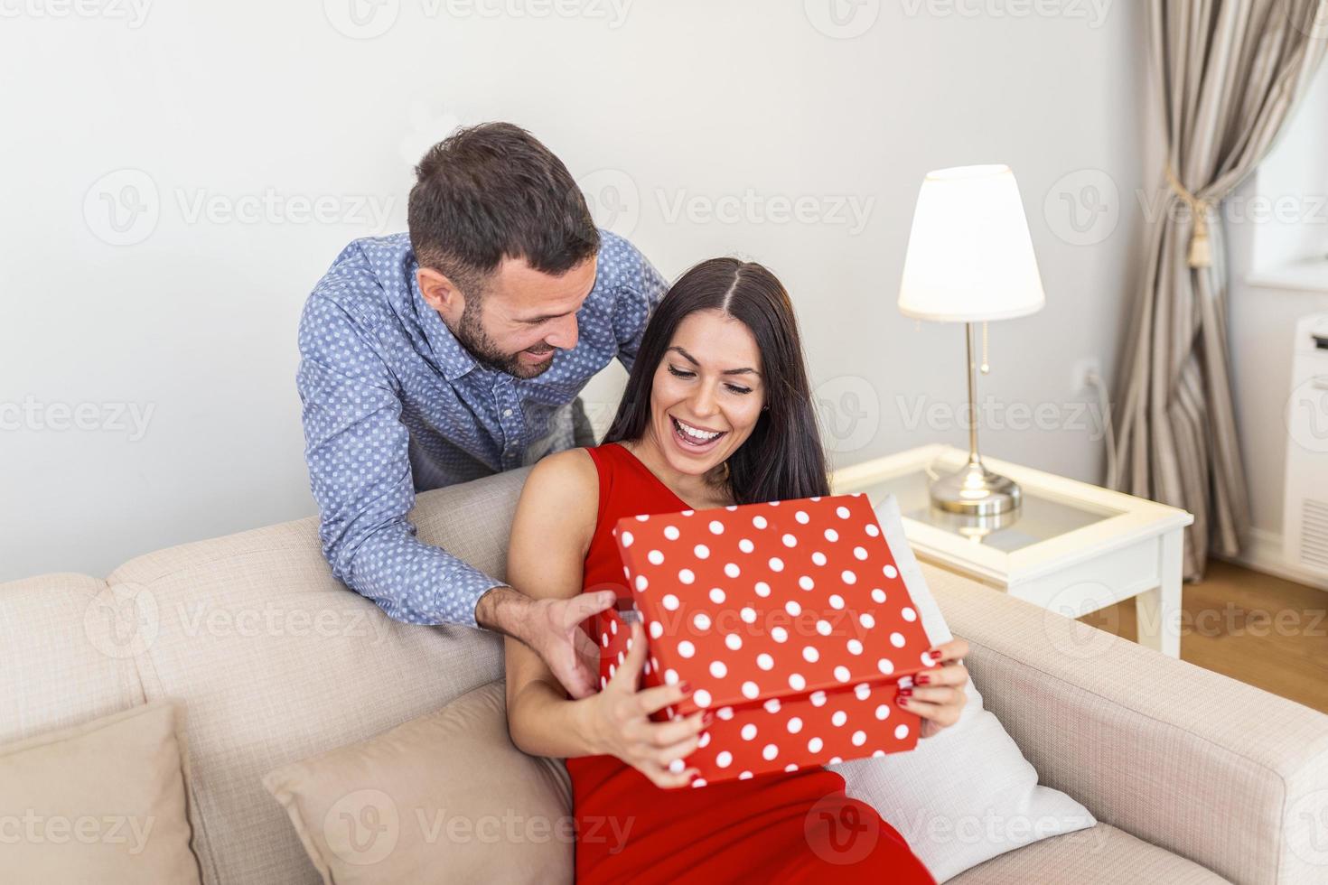 pareja joven en casa sosteniendo un regalo. hombre sorprendiendo a su  esposa con caja de regalo en el día de san valentín. 8 de marzo feliz día  de la mujer 14445471 Foto